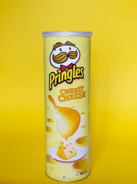 Bir kutu dolusu Pringles çedar peyniri cips Sarı zemin üzerine