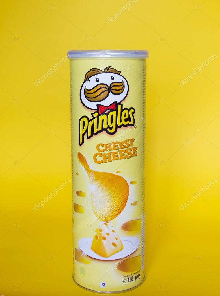 KYIV, UKRAINE - MAY 20, 2016: A can of Pringles Cheddar Cheese chips on yellow background. Pringles is a brand of potato snack chips owned by The Kellogg Company.