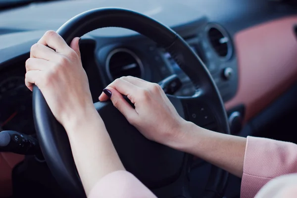 Vrouw handen druk op de knop op een stuurwiel in auto — Stockfoto