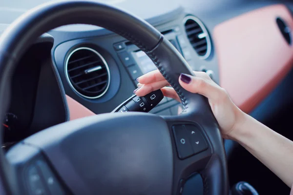 Kvinna händer tryck på knappen på en ratt i bil — Stockfoto