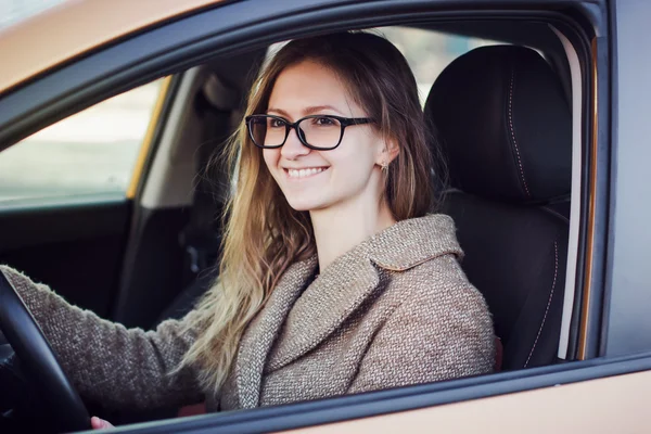 Leende ung kvinna som kör sin bil — Stockfoto