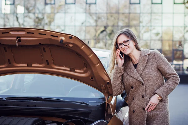Leende ung kvinna talande telefon nära bil — Stockfoto