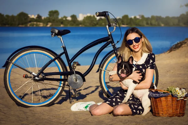 Mulher bonita na praia com bicicleta e bulldogs franceses — Fotografia de Stock