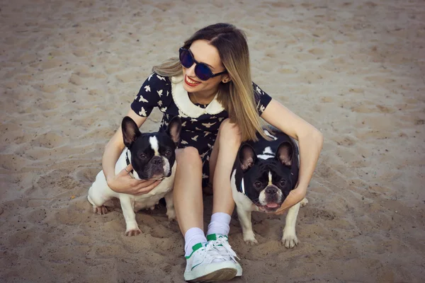 Krásná dívka na pláži s dvěma francouzský buldok — Stock fotografie
