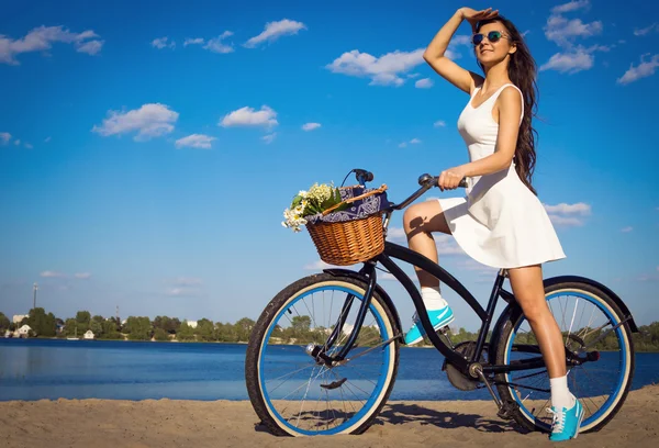 Mulher bonita na praia com bicicleta de cruzeiro — Fotografia de Stock