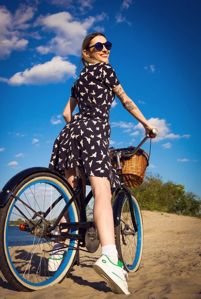 Красива молода жінка на пляжі з круїзним велосипедом — стокове фото
