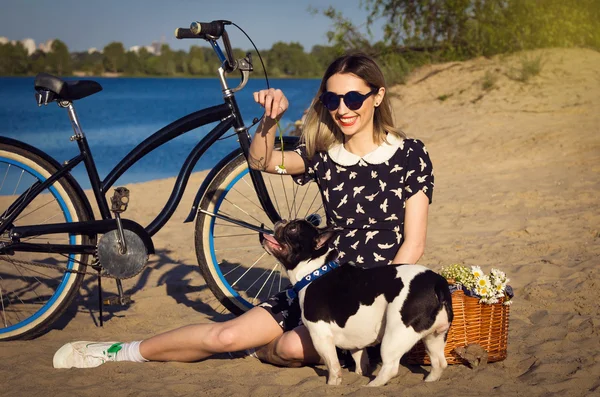 Schöne junge Frau am Strand mit Fahrrad und französischen Bulldoggen — Stockfoto