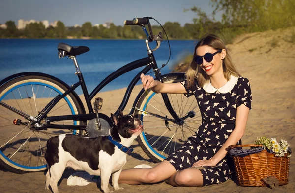 Hermosa joven en la playa con bicicleta y bulldogs franceses —  Fotos de Stock