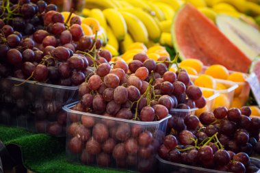 Bir çiftçi pazarda kutularındaki üzüm