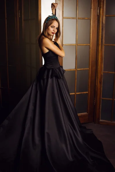 Moda hermosa mujer en vestido largo negro y corona de diamantes — Foto de Stock
