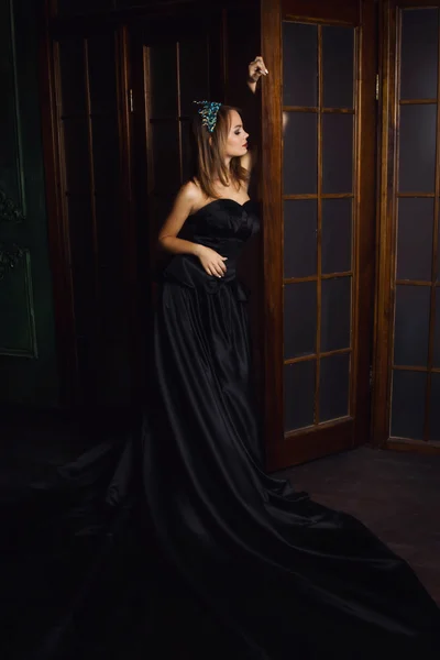 Moda hermosa mujer en vestido largo negro y corona de diamantes — Foto de Stock