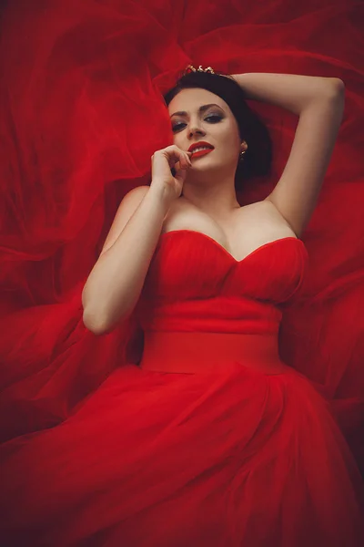 Preciosa mujer en vestido rojo con corona — Foto de Stock