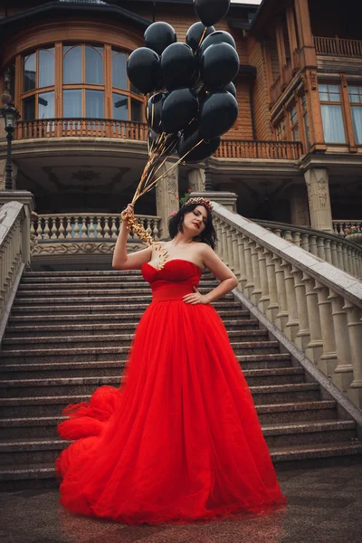 Femeia superba in rochie rosie cu baloane negre — Fotografie, imagine de stoc