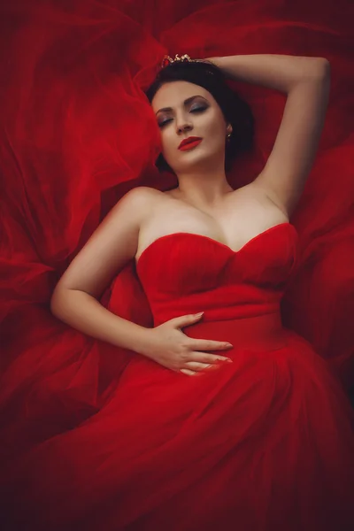 Preciosa mujer en vestido rojo con corona — Foto de Stock