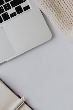 Dizüstü bilgisayarın üst görünümü, beyaz arkaplanda defter ve kalem aç
