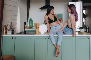 Mutfak masasında oturan lezbiyen çift.