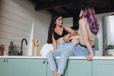 Mutfak masasında oturan lezbiyen çift.