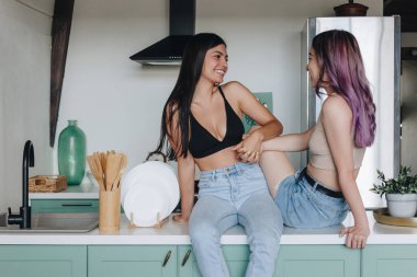 Mutfak masasında oturan lezbiyen çift.