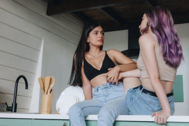 Mutfak masasında oturan lezbiyen çift.