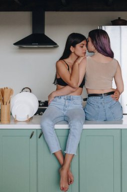 Mutfak masasında oturan lezbiyen çift.