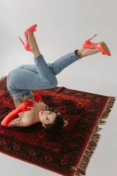 Sexy Frau Mit Tätowierungen Trägt Jeans Und Rote Handschuhe Auf — Stockfoto