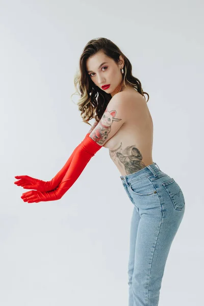 Sexig Kvinna Med Tatueringar Bär Jeans Och Röda Handskar Vit — Stockfoto