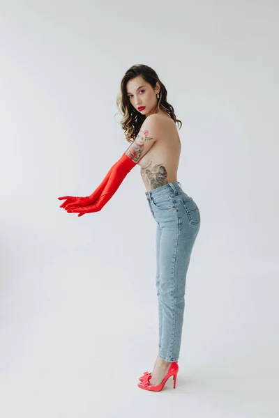 Mulher Sexy Com Tatuagens Vestindo Jeans Luvas Vermelhas Fundo Branco — Fotografia de Stock