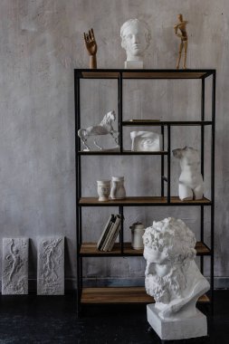 Heykeller ve kitaplarla dolu çatı katı stüdyosu.