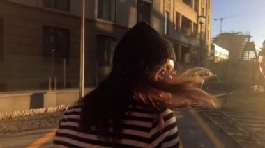 Beyaz kadının çizgili yelek giyip dışarıda eğlendiği yavaş çekim videosu.