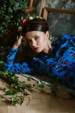 Frida Kahlo gibi saçları ve kırmızı dudakları olan güzel bir genç kadının portresi.