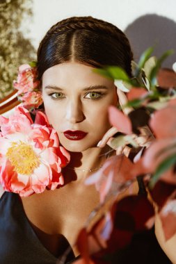 Şakayık çiçekli güzel bir genç kadının portresi.