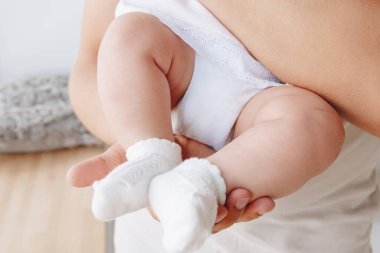 Baba ellerinde bebek ayakları tutuyor.