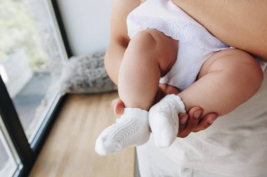 Baba ellerinde bebek ayakları tutuyor.