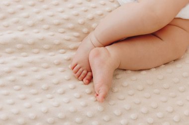 Bej ekose üzerinde küçük bebek bacakları