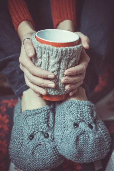 Knitted grey slippers and cup Royalty Free Stock Images