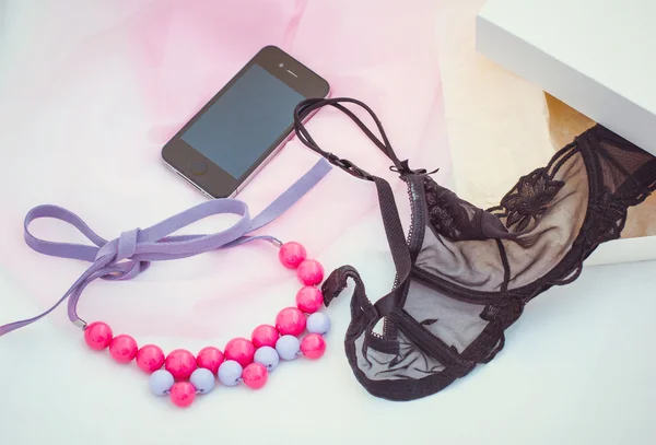 Kolye, telefon ve siyah dantel sütyen Üstten Görünüm — Stok fotoğraf