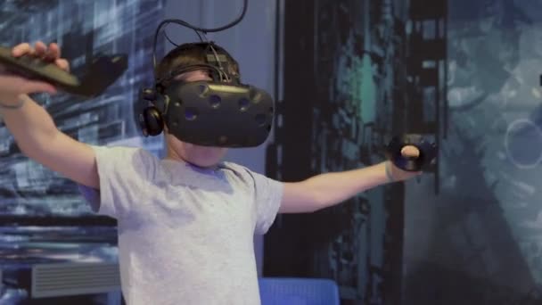 Хлопчик-підліток грає у шоломі віртуальної реальності в ігровому клубі — стокове відео