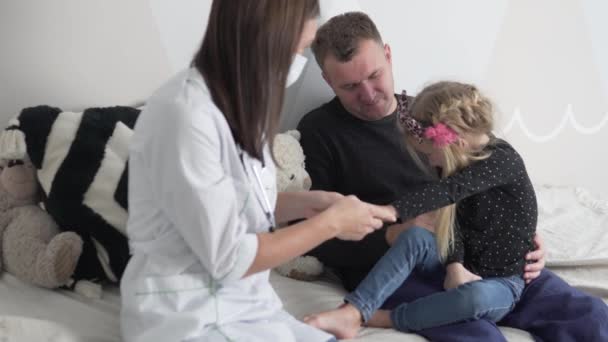 Eine Ärztin gibt einem kleinen Mädchen sein Stethoskop und streicht dem Baby über die Hand — Stockvideo