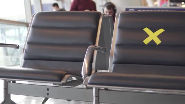 Une touriste féminine pour s'asseoir sur une chaise sur laquelle vous pouvez vous asseoir à l'aéroport. — Video