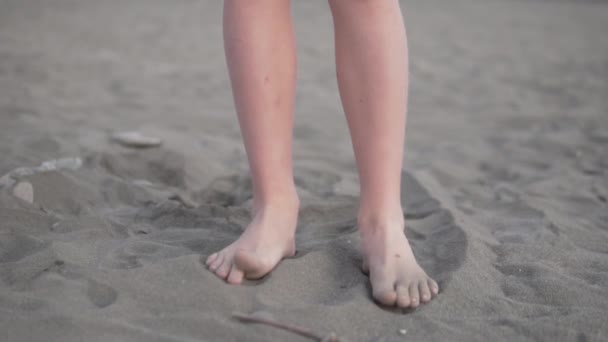 Zbliżenie stóp dzieci w czarnym piasku na plaży — Wideo stockowe