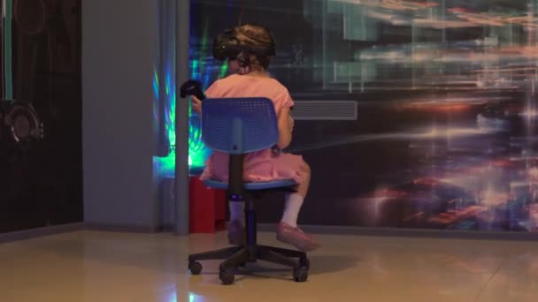 Dívka ve věku 8 let hraje v počítačových klubech ve virtuální realitě ve viar brýle a s dálkovým ovládáním — Stock video