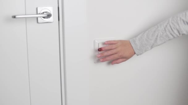 Крупный план руки ребенка с поврежденным пальцем включает свет в комнате — стоковое видео