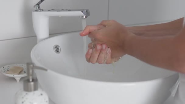 Gros plan, une femme se lave soigneusement les mains avec du savon à la maison dans la salle de bain — Video