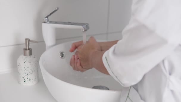Eine Ärztin wäscht ihr Gesicht mit Wasser. — Stockvideo