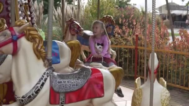 I bambini cavalcano un cavallo su un'altalena in un parco divertimenti ad Halloween — Video Stock