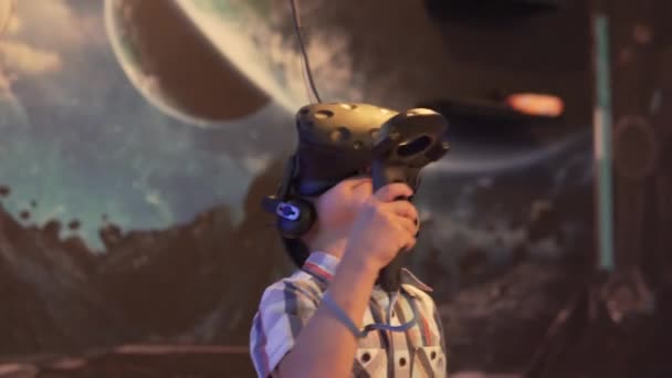 Een jongen met een virtual reality bril speelt een computerspel in een Viar club — Stockvideo