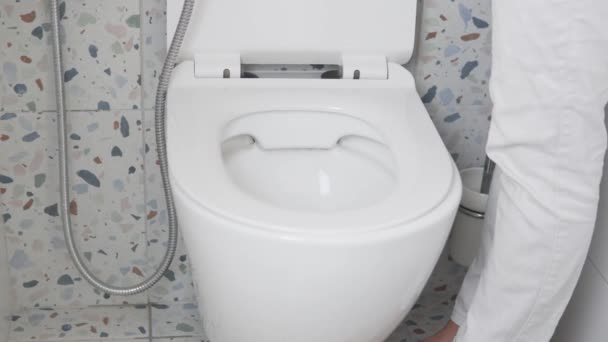 Het appartement schoonmaken. Een vrouw in handschoenen wast het toilet met een hygiënische douche — Stockvideo
