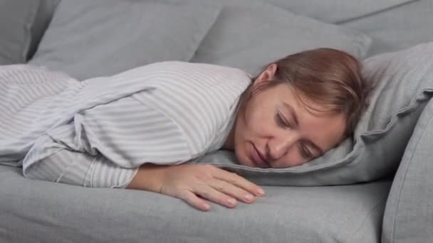 Lazy housewife falls on the sofa with pillows and falls asleep — Stock Video