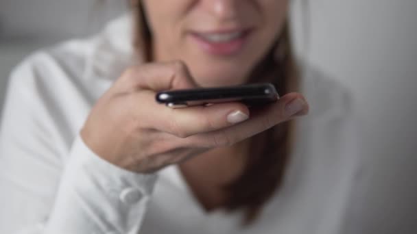 Una mujer graba un mensaje de audio en su teléfono — Vídeos de Stock