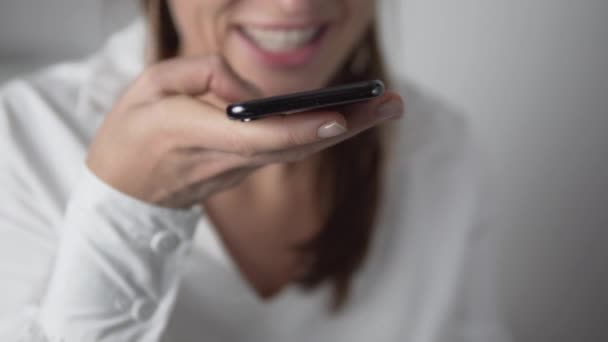 Una mujer deja un mensaje de voz en su teléfono móvil. — Vídeo de stock